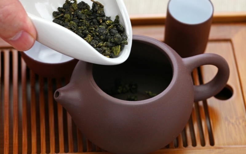 Cho trà và nước nóng vào ấm với lượng vừa đủ